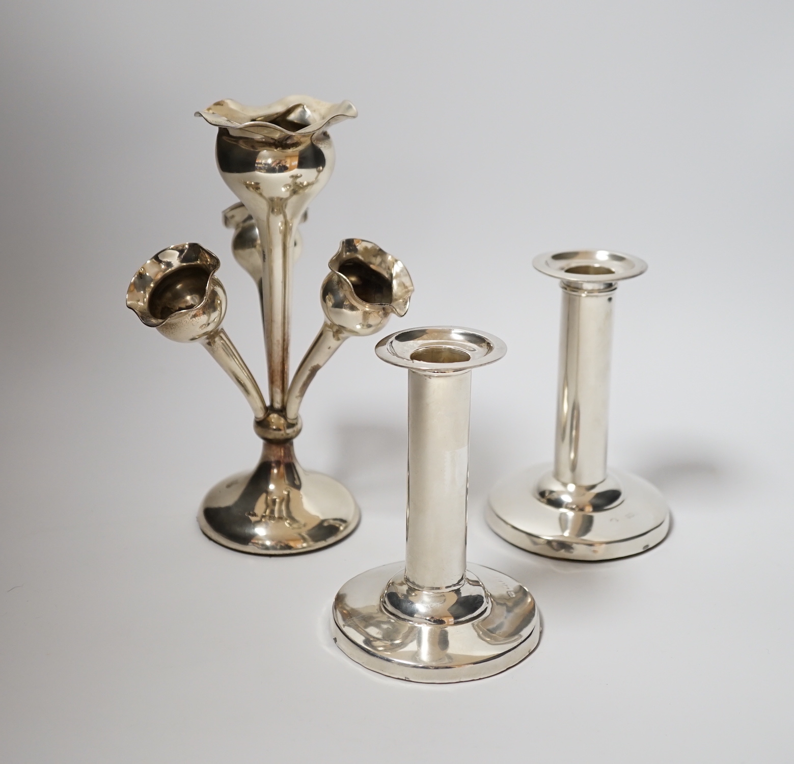 A pair of Edwardian silver mounted dwarf candlesticks, by William Hutton & Sons, London, 1904, 11cm, weighted, together with a late Victorian small silver centrepiece with four receivers.